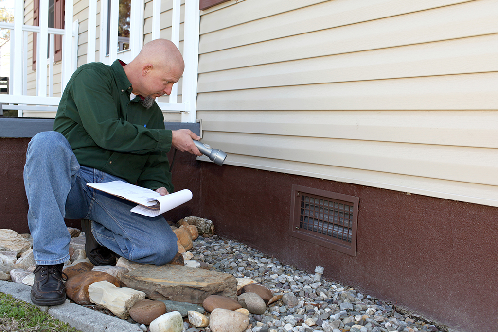 Inspector examining home exterior details